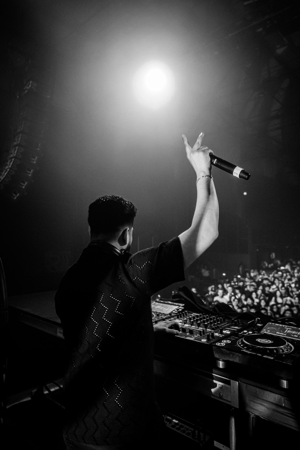DJ Diego Fernandez on the mic under a spotlight