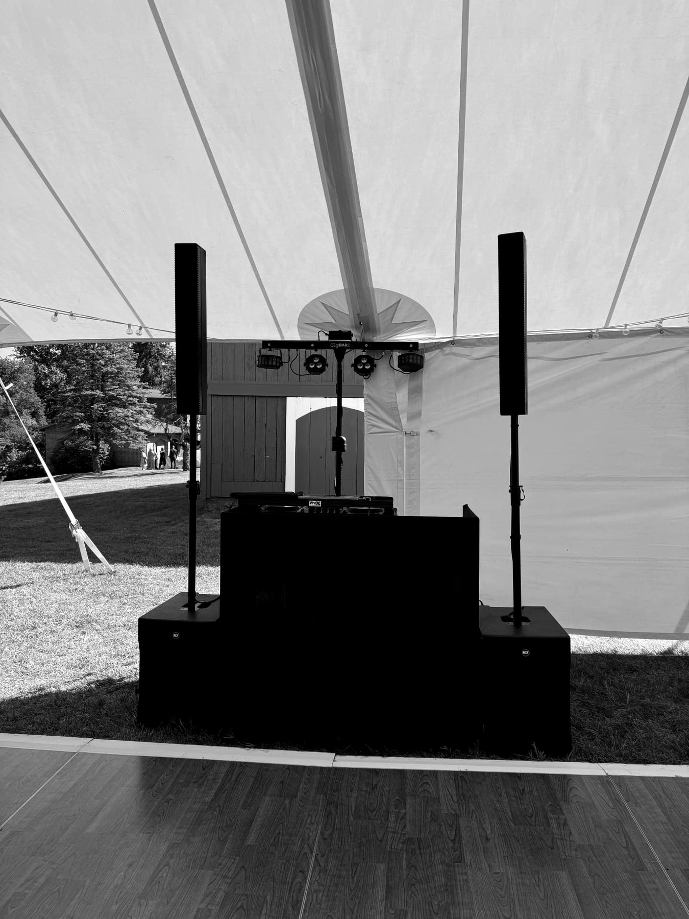 Wedding tent DJ setup with line array speakers and lighting